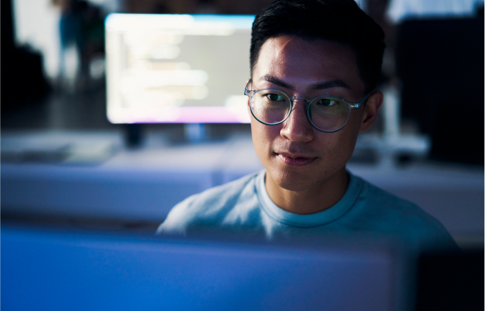 Asian man looking at his screen with a smile